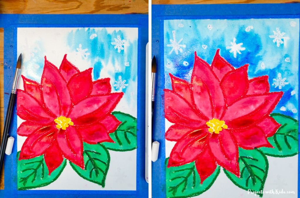 Painting a poinsettia art project background with blue watercolor paint.