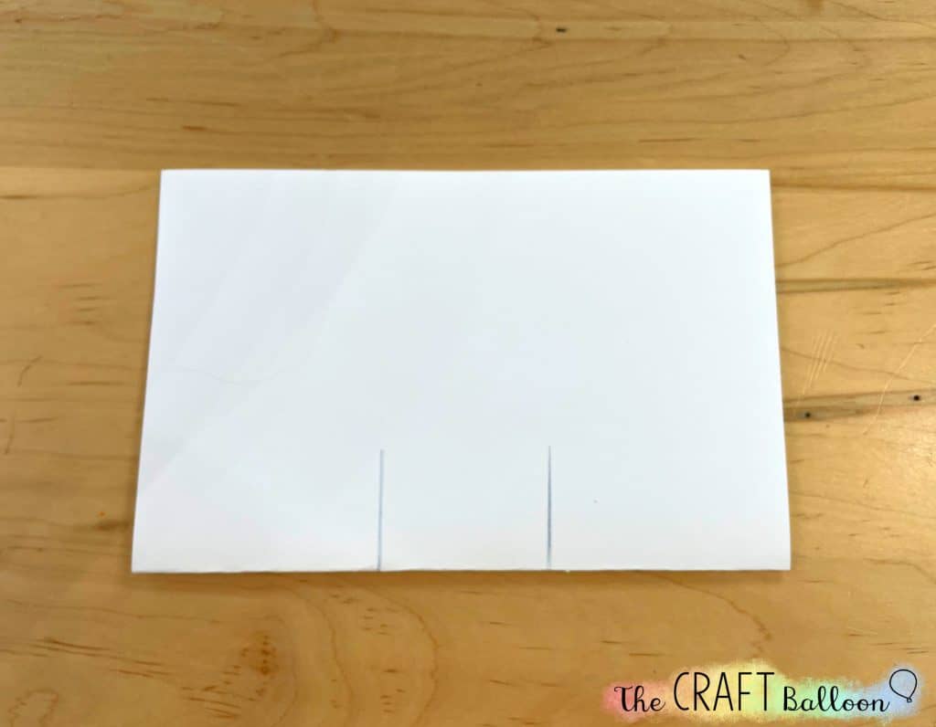 letter sized paper folded in half with two 4cm vertical lines drawn from the crease upwards